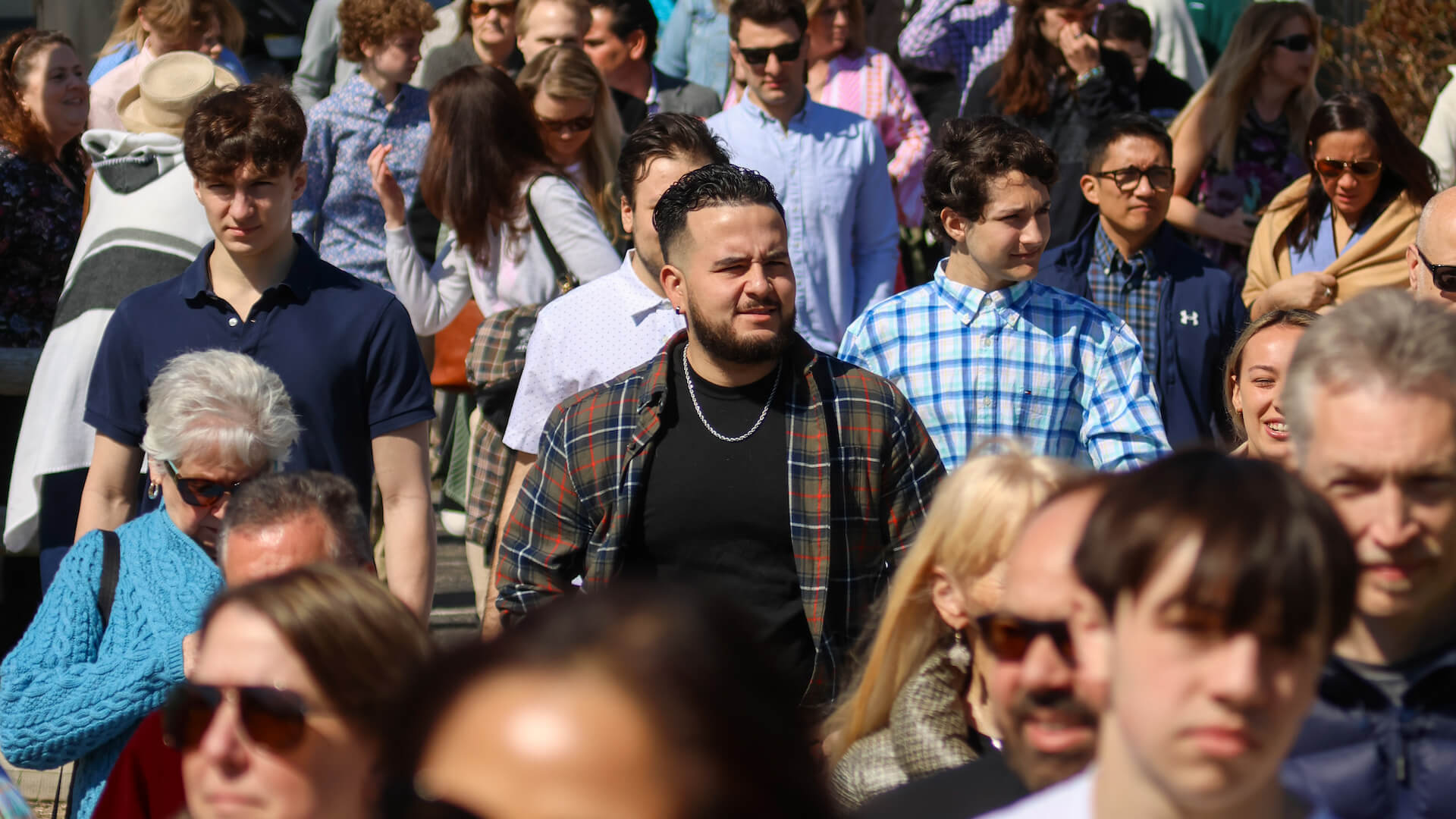 man in plaid shirt among group of people