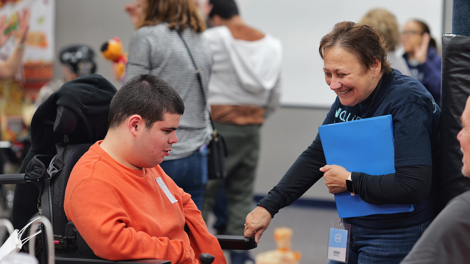 kid in wheelchair with woman smiling at him