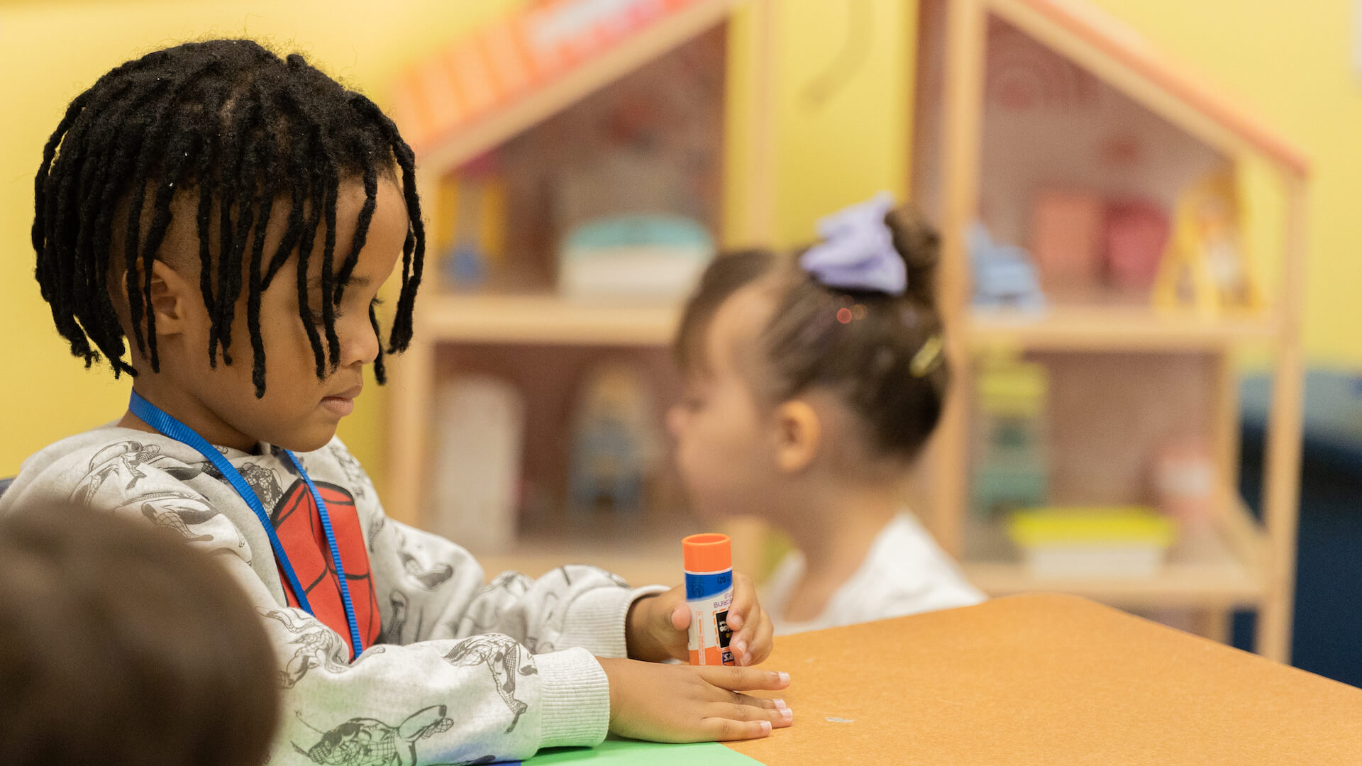 child playing with glue stick