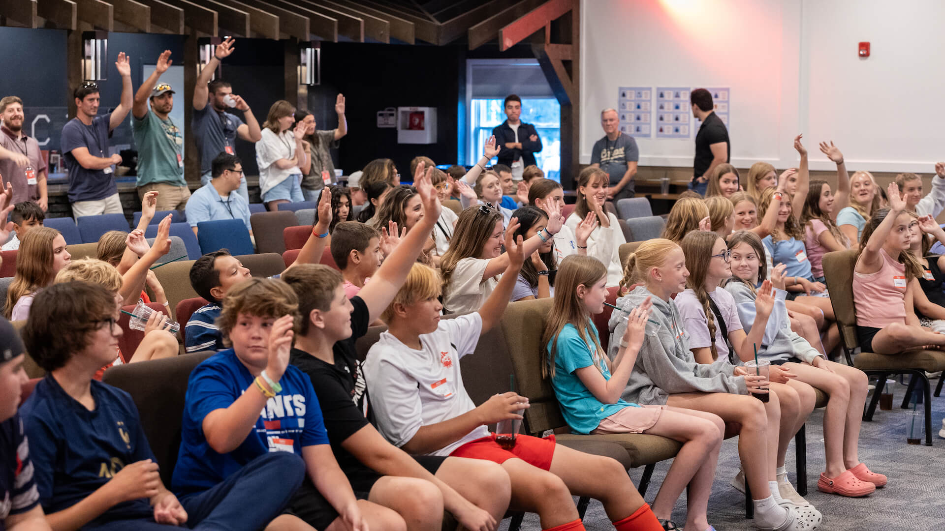 crowd of students with some raising hands